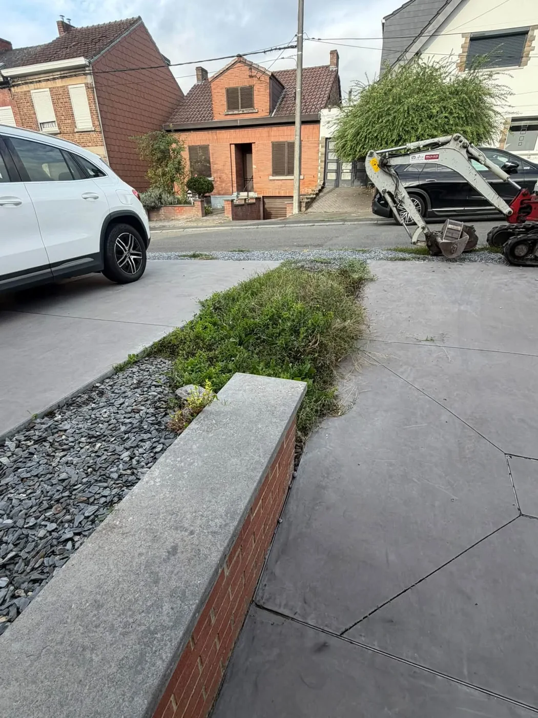 Bande de terre végétalisée le long d’une allée avant les travaux de retenue.